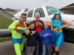 Pilots with Chatham-Kent Flight 203 of the Canadian Owners and Pilot Association provided free flights to kids on Saturday. From left are Capt. Positive, Landon Dorion, 8, pilot Gilles Michaud, Ezra Postma, 8, and OptiWoman. (Trevor Terfloth/The Daily News)