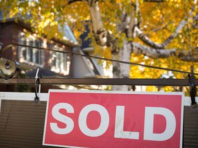 A real estate sold sign hangs in front of home. THE CANADIAN PRESS/Graeme Roy