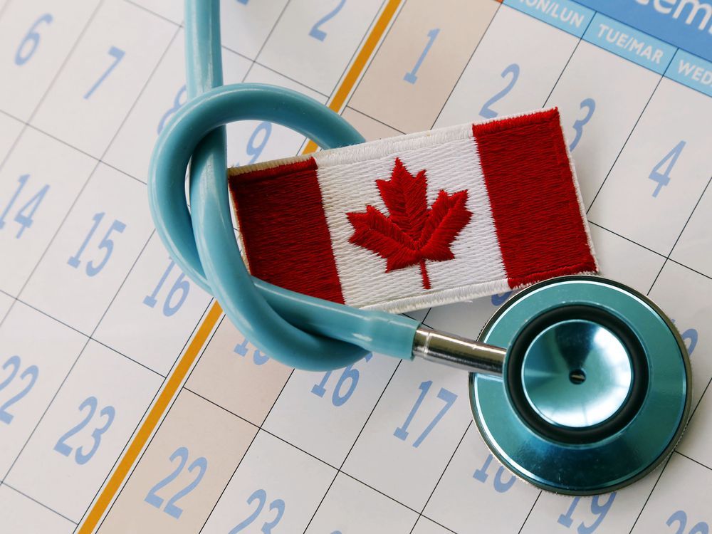 A stethoscope tied around a Canadian flag patch rests on a calendar