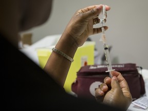 A flu shot needle is being prepared.