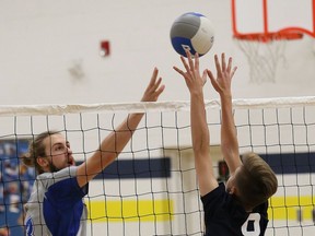 Jacob Paradis, left, of Sacre-Coeur Griffons, attempts to tip the ball past Andrew Lewis, of the Bishop Carter Golden Gators, during high school volleyball action at Bishop Alexander Carter Catholic Secondary School in Hanmer, Ont. on Monday October 22, 2018. John Lappa/Sudbury Star/Postmedia Network