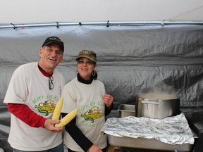 Reynald Brisson hands some more corn to Lucille Nelson as they cook ears of corn for the annual Korn for Kids fundraising event.