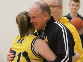 St. Mike's senior girls basketball coach Steve Goforth embraces Jess Findlay Robinson during the medal ceremony after winning an eighth straight Huron-Perth title in 2018.