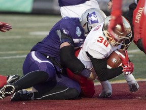 Laval Rouge et Or's Alexis Cote dives in the end zone to score the last touchdown against the Western Mustangs at the Vanier Cup in Quebec City, Saturday, Nov. 24, 2018. Laval won 34-20. Mustangs' Austin Fordham-Miller is on Cote's back. THE CANADIAN PRESS/Jacques Boissinot