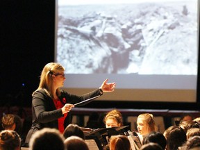 Stratford District Secondary School (then Stratford Central) music teacher Paula Ortelli conducts the school's symphonic band while historic war photos are shown during a Remembrance Day ceremony on Friday November 9, 2018 in Stratford, Ont. (Beacon Herald file photo)