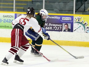 Lauren Hancock of the Lockerby Vikings (9) carries the puck toward the goal while Grace Racicot of the St. Charles Cardinals defends during SDSSAA girls hockey action at Garson Arena in Garson, Ontario on Wednesday, December 19, 2018.