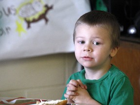 Evan Skinner, 4 , joins his class in prayer Thursday before enjoying a festive meal.
