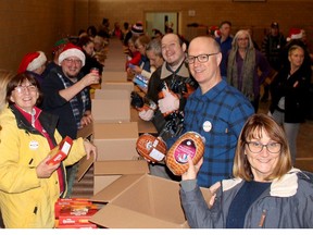 Several volunteers have some fun while packing food boxes for the Chatham Goodfellows No Child Without A Christmas campaign at the Spirit & Life Centre in Chatham, Ont. on Tuesday December 18, 2018. Ellwood Shreve/Chatham Daily News/Postmedia Network