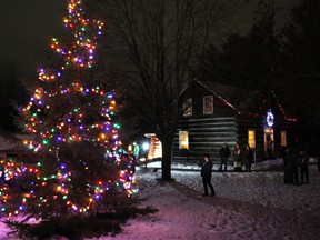 The light from the Christmas tree at the Champlain Trail Museum and Pioneer Village holds back the cold winter darkness while attendees to the official tree lighting in 2018 enjoy its holiday glow.
