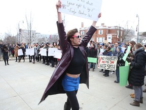 A counter protester carries a sign supporting free speech at a protest against a talk by Jordan Peterson. Postmedia Network