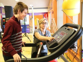 Bennett Radey, 11, a client at the NEO Kids Children's Treatment Centre at Health Sciences North, demonstrates his exercise routine with the help of physiotherapist Mary Sabo at the grand opening celebration of a  Smilezone in the CTC gymnasium in 2018.