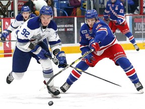 Blake Murray, left, of the Sudbury Wolves, and Greg Meireles, of the Kitchener Rangers, battle for the puck during OHL action at the Sudbury Community Arena in Sudbury, Ont. on Friday December 14, 2018.