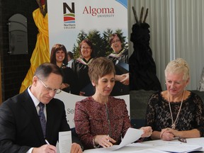 Fred Gibbons, from left, president and chief executive officer of Northern College and Asima Vezina, president and vice-chancellor of Algoma University, sign joint admission agreements to support enhanced student mobility between the college and the university. Audrey Penner, vice-president of Academic and Student Success at Northern College, is seen here looking on. RON GRECH/POSTMEDIA FILE PHOTO