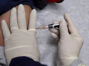A medical assistant at the Sea Mar Community Health Center gives a patient a flu shot in Seattle on January 11, 2018. Canadian researchers say this season's influenza vaccine appears to have reduced the risk of infection with the dominate circulating flu strain by 72 per cent - far higher than what was seen with last year's shot.THE CANADIAN PRESS/AP/Ted S. Warren