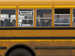 Kids wave as they ride the school bus in Fort McMurray on Thursday, April 6, 2017. Ian Kucerak / Postmedia
