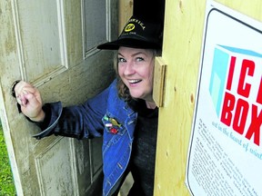 Krista Dalby peeks out from one of the wooden huts used for past editions of Ice Box art event. They're not in use this year, as the event switches to an outdoor art show and activity kits for kids.