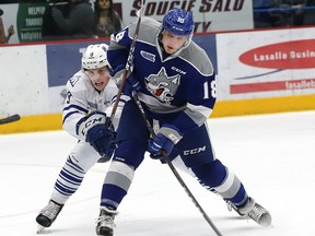 Owen Robinson, right, of the Sudbury Wolves, is checked by Keean Washkurak, of the Mississauga Steelheads, during OHL action at the Sudbury Community Arena in Sudbury, Ont. on Friday January 11, 2019.