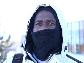 Laurentian University student David Kouassi attempts to keep warm while catching a bus at the Sudbury, Ont. in this file photo.