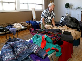 Walter Durante, a volunteer with the Hotel Dieu-St. Mary's Cathedral Coat Drive, organizes coats at the St. Mary's Parish centre in Kingston in November 2018, just before clients arrived to pick up free winter coats and other cold-weather items. (Ian MacAlpine/The Whig-Standard)