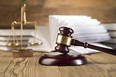 Golden scales of justice, gavel and books wood brown background