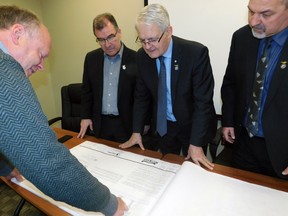 Kenora MP Bob Nault, Transport Minister Marc Garneau and Red Lake Mayor Fred Mota review plans for the Red Lake Municipal Airport. SUPPLIED
