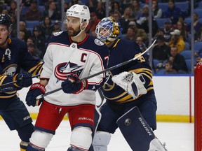 Buffalo Sabres goalie Linus Ullmark (35) is screened by Columbus Blue Jackets forward Nick Foligno (71) during the first period of an NHL hockey game Sunday, March 31, 2019, in Buffalo, N.Y.