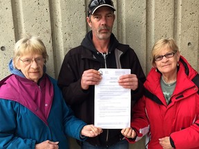 The family of John Janssens, 73, who died in early 2016, about two months after falling from a roof in Wallaceburg, Ont., hold a copy of the nine recommendations that came out of an inquest into his death as well as two other men who also died as result of falling from a roof. Pictured from left is Eileen Janssens, left, widow, Dale Janssens, son, and Jane Daniels, sister-in-law,  in Chatham, Ont. on Thursday April 11, 2019. (Ellwood Shreve/Chatham Daily News)
