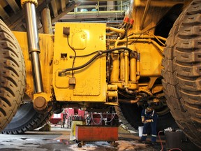 A Syncrude worker changes the oil on a Caterpillar 797 heavy hauler at a machine shop north of Fort McMurray, Alta. on Tuesday August 15, 2017. Vincent McDermott/Fort McMurray Today/Postmedia Network