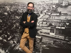 City curator Paul Robertson stands in front of an old photo of Kingston's downtown in April 2019.