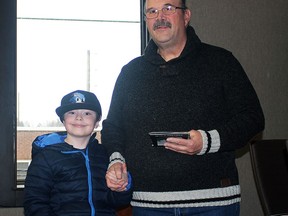 Kirkland Lake's homeschooled kids  received 100th anniversary coins. In the photo is Carson St. Jean receiving his from town councillor Dennis Perrier.