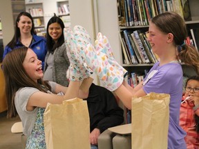 Cecelia Graham (left) and Kaylee Philipation play with the oven mitts they won as the champions of Master Chef Junior at the Melfort Library on Thursday, April 25.