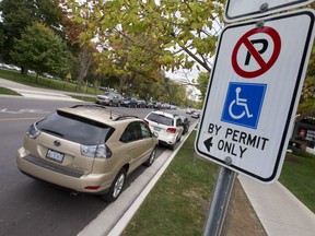 A sign on a post identifies this Dufferin Avenue parking spot, near the corner of Richmond Street, is for drivers with a disability permit, in London, Ont. on Tuesday October 18, 2016. Rick Gleed believes the space needs more than minimum signage, such as markings on the pavement, as the space generates many tickets.  Craig Glover/The London Free Press/Postmedia Network