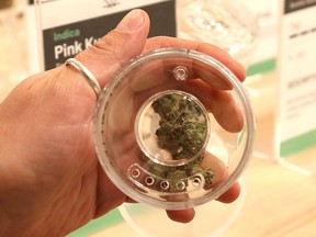 Eugene Konarev, manager and brand creator of HighLife, displays a jar holding product at the cannabis retail outlet in Sudbury.