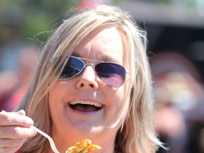 Nancy Thompson, from Atlanta, Georgia, enjoys a classic poutine at Poutine Feast on Saturday, June 29, 2019 in Sault Ste. Marie, Ont. A Poutine Feast event will be held in Wiarton on the Labour Day weekend in 2022. (BRIAN KELLY/THE SAULT STAR/POSTMEDIA NETWORK)