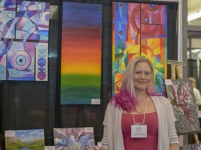 Local artist Stephanie de Souza poses with a few of her paintings at the Airdrie Home and Lifestyle Show on Saturday, April 27, 2019.