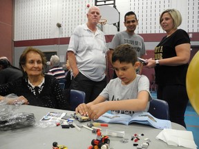 Ethan Mahajan, 6, concentrated on a Lego project during a blood donation clinic last year. With him were his grandmother Sarla Mahajan (left); grandfather Doug Sinclair, and parents Aseem and Tracy Mahajan. (Expositor file photo)