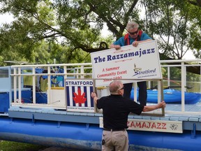 Razzamajazz organizers Dan Scarborough and Robert Paton put their new signs on the side of the barge before it went in the water in 2019.