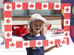 Adelyn Jamieson, 5, was a picture of patriotism as she peeked through a flag-decorated frame that was on hand during the pre-Canada Day celebrations at the Urban Park in Downtown Timmins during last year's celebrations. This year's events will be held entirely online due to the COVID-19 pandemic. RICHA BHOSALE/THE DAILY PRESS