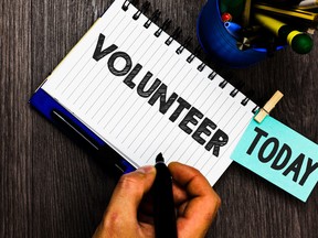 Text sign showing Volunteer. Conceptual photo Volunteering individual for greater social cause serving others Reminder appointment daily work pens penholder clip paperclip papers.