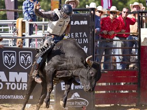 Taylor Watson of Grimsby rides a bull named Texas Mickey on Saturday in a bull riding competition, part of the two-day Norfolk Ram Rodeo on Saturday July 20, 2019 in Nixon, Ontario.