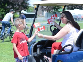 Malek Carriere receives a Canada flag from a volunteer during the Canada Day celebrations in Lamoureux Park on Monday July 1, 2019 in Cornwall, Ont. Nick Dunne/Cornwall Standard-Freeholder/Postmedia Network