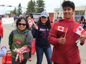 Volunteers hand out Canadian flags during the Canada Day Parade in downtown Fort McMurray on Monday, July 1, 2019. Vincent McDermott/Fort McMurray Today/Postmedia Network