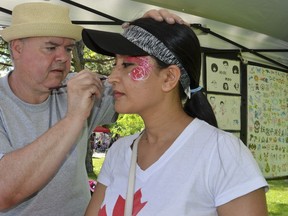 Muna Shrestha has fireworks and maple leafs painted on her face by Rick Gowing in Kelso Beach Park during Canada Day celebrations on Monday, July 1, 2019 in Owen Sound, Ont. She moved to Canada from Nepal three years ago to provide a better life for her daughter, Ivanna. Scott Dunn/The Owen Sound Sun Times/Postmedia Network