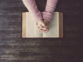 Hands clasped over bible