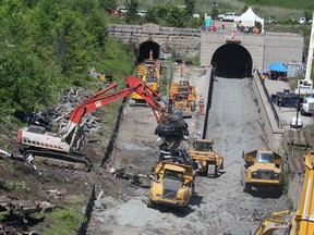 A crushed automobile is loaded on a dump truck Monday on the Canadian side of the St. Clair River tunnel where crews were cleaning up after approximately 40 rail cars derailed early Friday. Work was also still underway Monday to remove sulphuric acid that spilled in the tunnel from one of the rail cars. The derailed cars included multi-level auto carriers.
