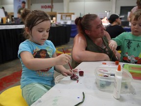 Shea-Cherri Waldrum, left, concentrates on painting a pebble while Jeanne Waldrum watches L.J. Taylor work on his own project at the Sudbury Gem and Mineral Show at Carmichael Arena in this file photo.