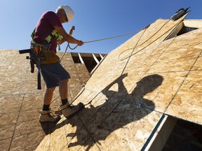 Rick Haasen of Shedden walks on a section of roof he was finishing on a Doug Tarry home. (Mike Hensen/Postmedia Network file photo)