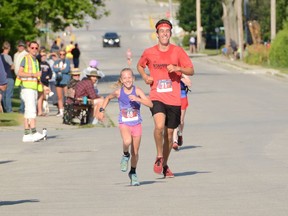 Eleven-year-old Keira Snelling of Red Bay runs toward the finish line alongside Nate Stephen of Beaverton at the 67th annual Shore to Shore race from Oliphant to Wiarton in August 2019. Snelling finished the 13.1-kilometre race in one hour, two minutes, and 31.1 seconds to win the 19-and-under female division. More than 130 runners and a handful of walkers took part in the event, put on by the Rotary Club of Wiarton, with funds raised going to various community projects and initiatives.
 Rob Gowan/The Owen Sound Sun Times/Postmedia Network