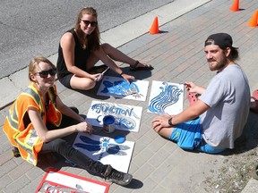 Miranda Virtanen, left, executive director of the Junction Creek Stewardship Committee, artist Katie Fenerty and volunteer Landon Noel apply stencil art to a sidewalk on Brady Street in Sudbury, Ont. on Wednesday August 7, 2019. The creek critter stencils, which are designed by Fenerty, are being painted in blue on  sidewalks along the route of Junction Creek. The stencil painting is part of the committee's Stream and Water  Quality Awareness project, which is part of the organization's initiative to "restore and maintain a healthy Junction Creek watershed." The project's goal is to promote better practices to reduce pollutants from entering the creek in stormwater runoff, and to raise awareness about the 800 metre section of Junction Creek that flows under the heart of downtown Sudbury. John Lappa/Sudbury Star/Postmedia Network