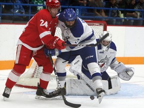 Sudbury Wolves goal Mitchell Weeks (35) watches a loose puck while Andre Anania (3) of the Wolves and Cole MacKay (24) of the Soo Greyhounds jockey for position during OHL pre-season action at Sudbury Community Arena in Sudbury, Ontario on Saturday, August 31, 2019.